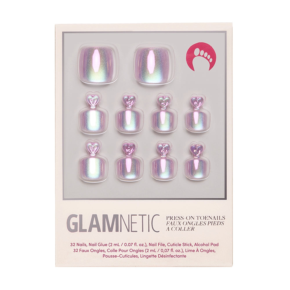 The Glamnetic Oyster Toenail set features 10 iridescent, pinkish-purple, pearlescent press-on toenails with a heart detail at the top, shown in a clear window on beige packaging.