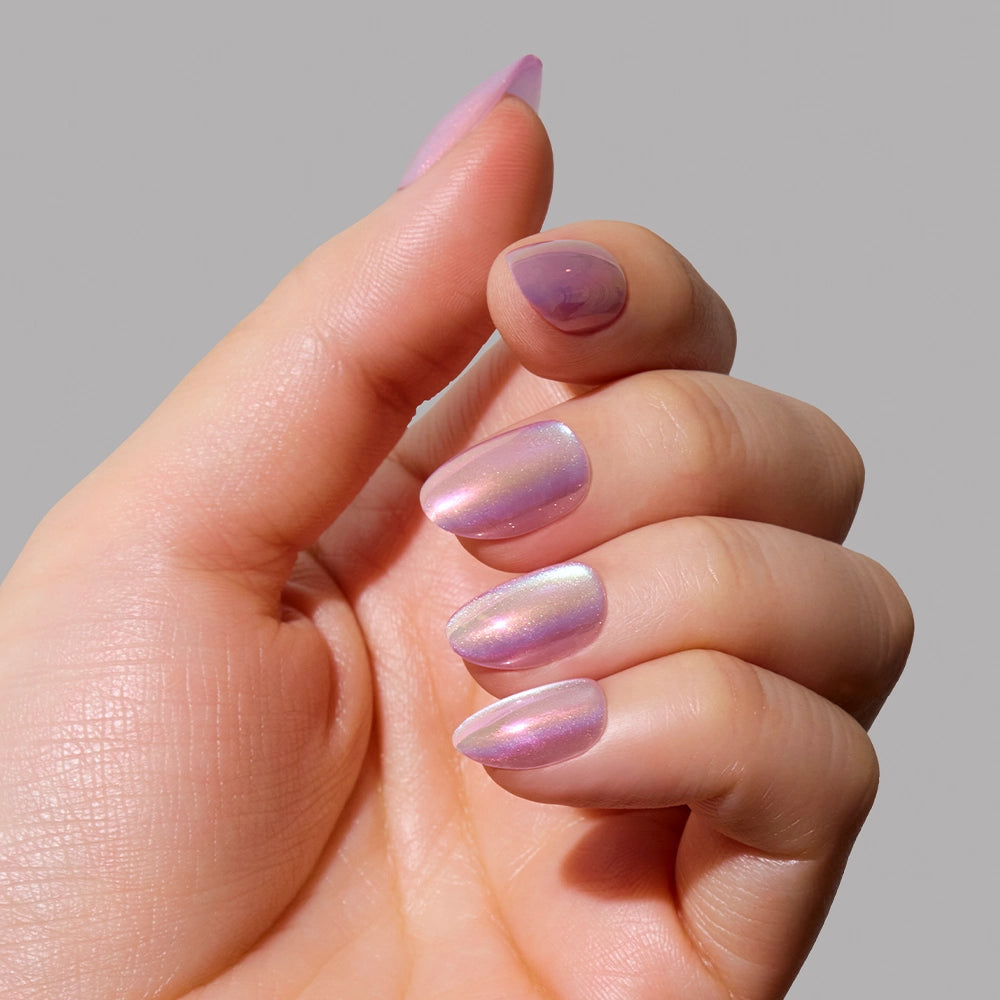 A hand with neatly manicured nails painted in glamnetics Oyster, a pearlescent purple shade with a subtle velvet finish, held against a plain gray background. - Product image
