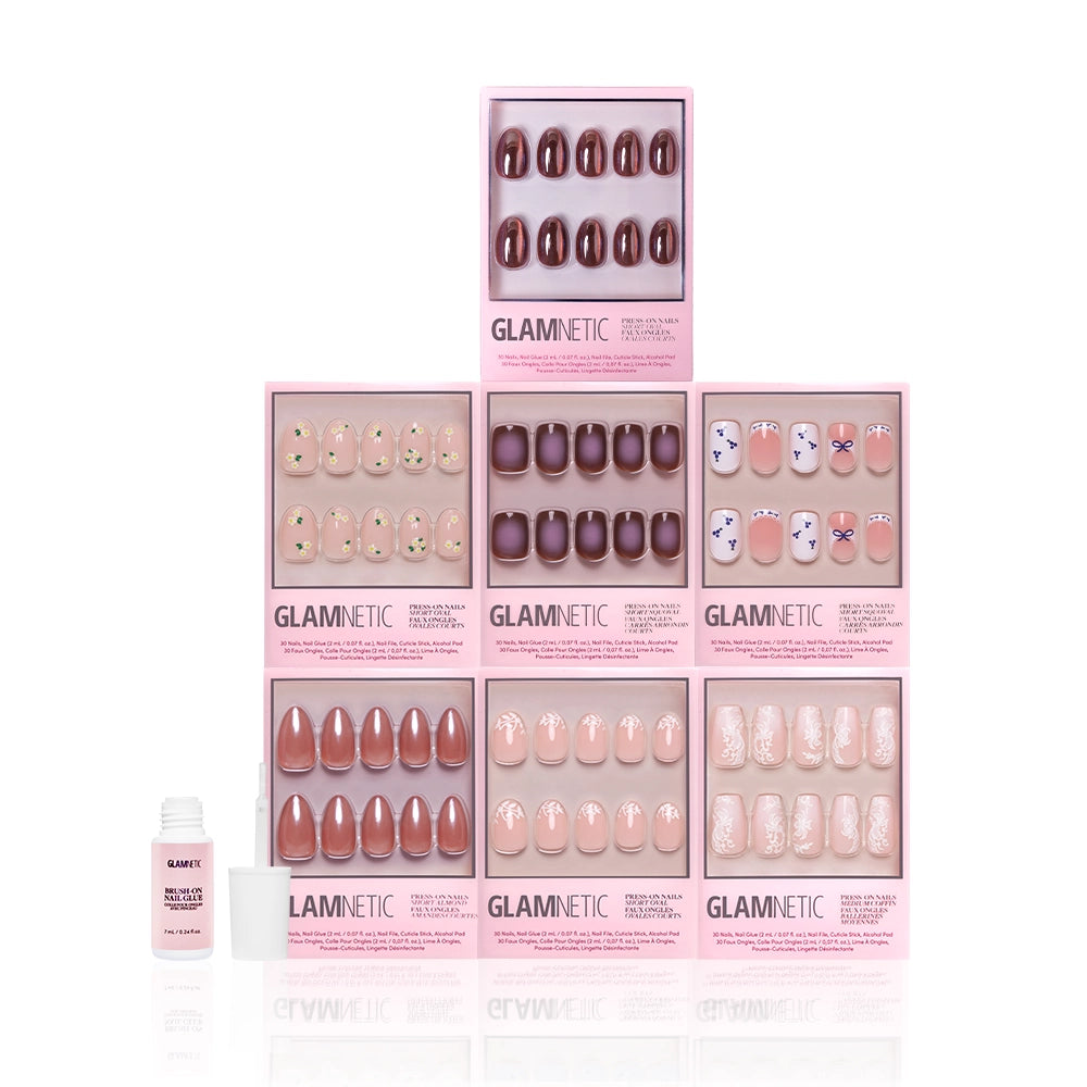 A display of seven glamnetic Rodeo Darling manicure nail sets in assorted colors and designs, arranged in a pyramid, with nail glue and an applicator placed in front. - Product image
