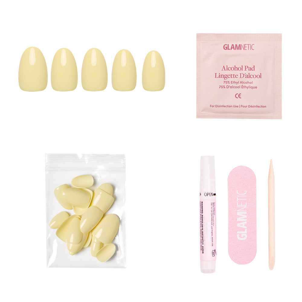The glamnetic Pastel Yellow Nail Set includes short oval nails with a salon-quality sheen, an alcohol pad, extra nails in a small bag, nail glue, a pink file, and a wooden cuticle stick—all displayed on a white background. - Product image