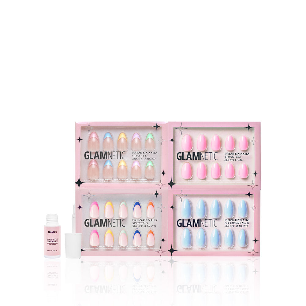 Four Glamnetic Pastel Princess press-on nail kits in pink boxes are shown, each featuring soft pastel, gradient, and French tip designs. A Brush On Nail Glue bottle is placed on the left. - Product image