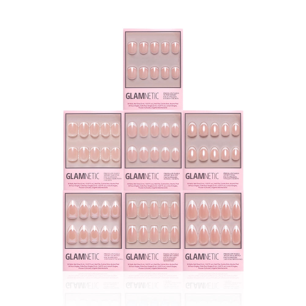 Eight boxes of glamnetic’s Pearl Posse Bundle press-on nails are stacked in a pyramid on a white background, each showing oval-shaped, light pink nails with chic glazed French tips for a pearlescent look. - Product image