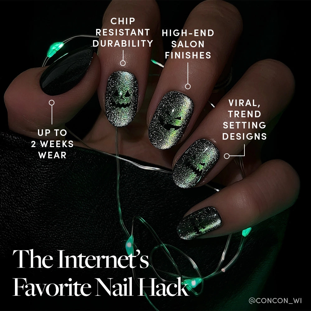 A hand with glamnetic Peek-o’-Lantern nails—black and glittery green magnetic velvet shimmer with Halloween designs. Enjoy chip-resistant durability, salon-quality finishes, reusable wear, viral trends, and up to 2 weeks of style. - Product image