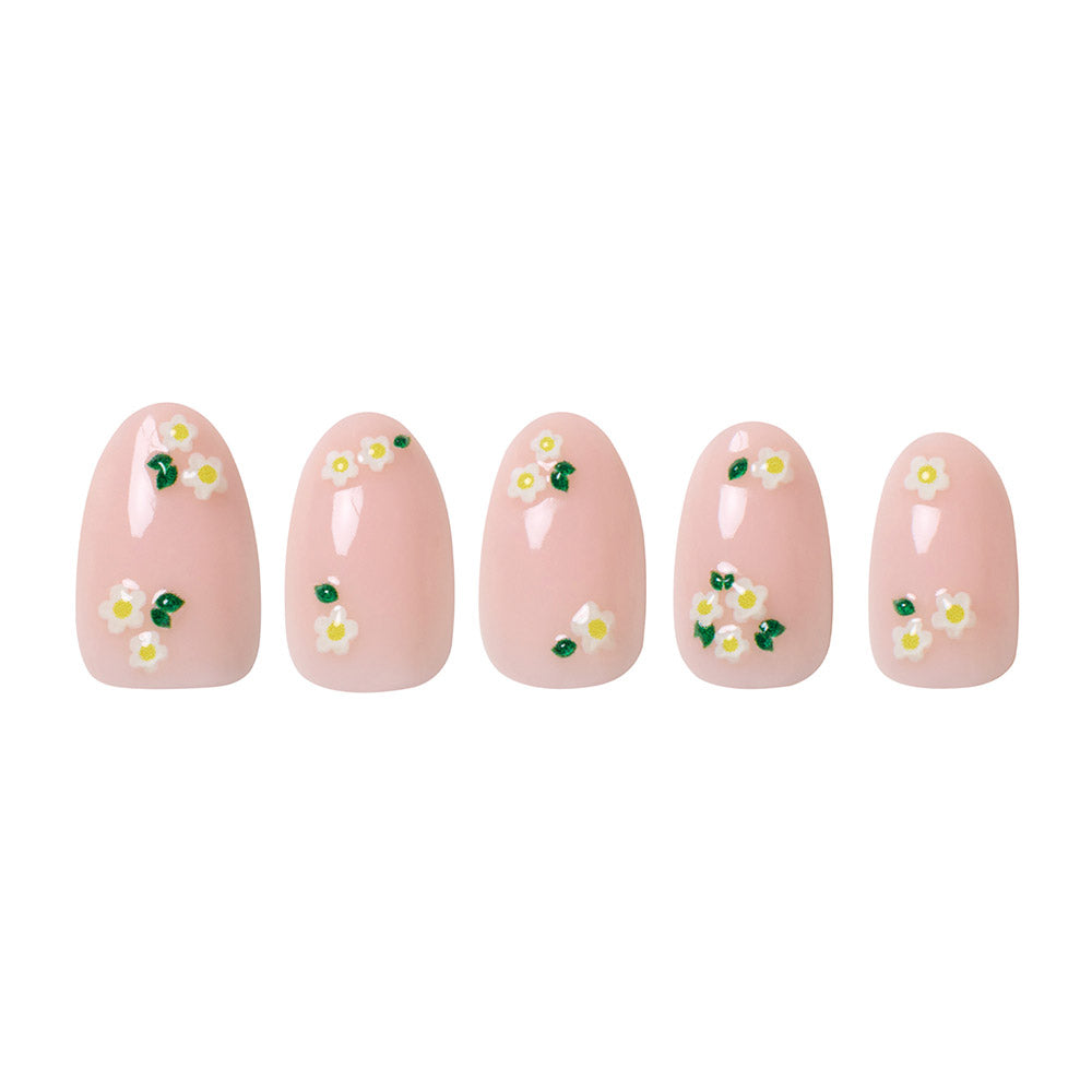 Five short oval nails from glamnetic’s Petals set are displayed side by side on a white background, featuring a light pink base, small white and yellow daisy floral accents, and a glossy finish. - Product image