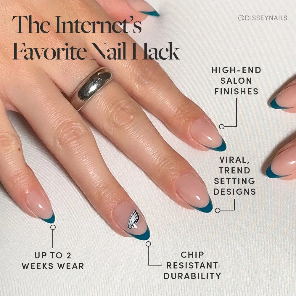 A hand with almond-shaped nails sports dark turquoise French tips and a logo accent, highlighting the Philadelphia Eagles Press-On Nail Set by glamnetic—offering long wear, chip resistance, a salon-quality finish, and on-trend designs. - Product image