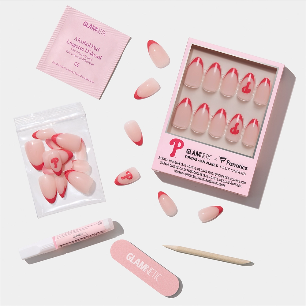 The glamnetic Philadelphia Phillies Press-On Nail Set features pink and red nails with a “P” design, arranged with a nail file, cuticle stick, glue, alcohol pad, and extra nails on a white background. - Product image