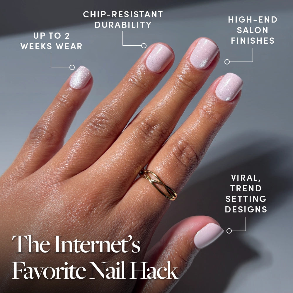 A hand with glamnetic Pink Legacy light pink press-on nails is shown, featuring up to 2 weeks of chip-resistant wear, salon-quality finishes, and viral trendsetting designs. A gold ring adds extra style. - Product image