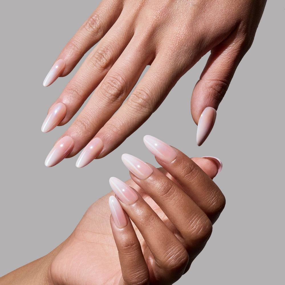 Two hands with long, almond-shaped glamnetic Pink Pearl Press-On Nails in a glossy light pink shade are posed against a plain gray background. The salon-quality nails provide a flawless, well-manicured look. - Product image