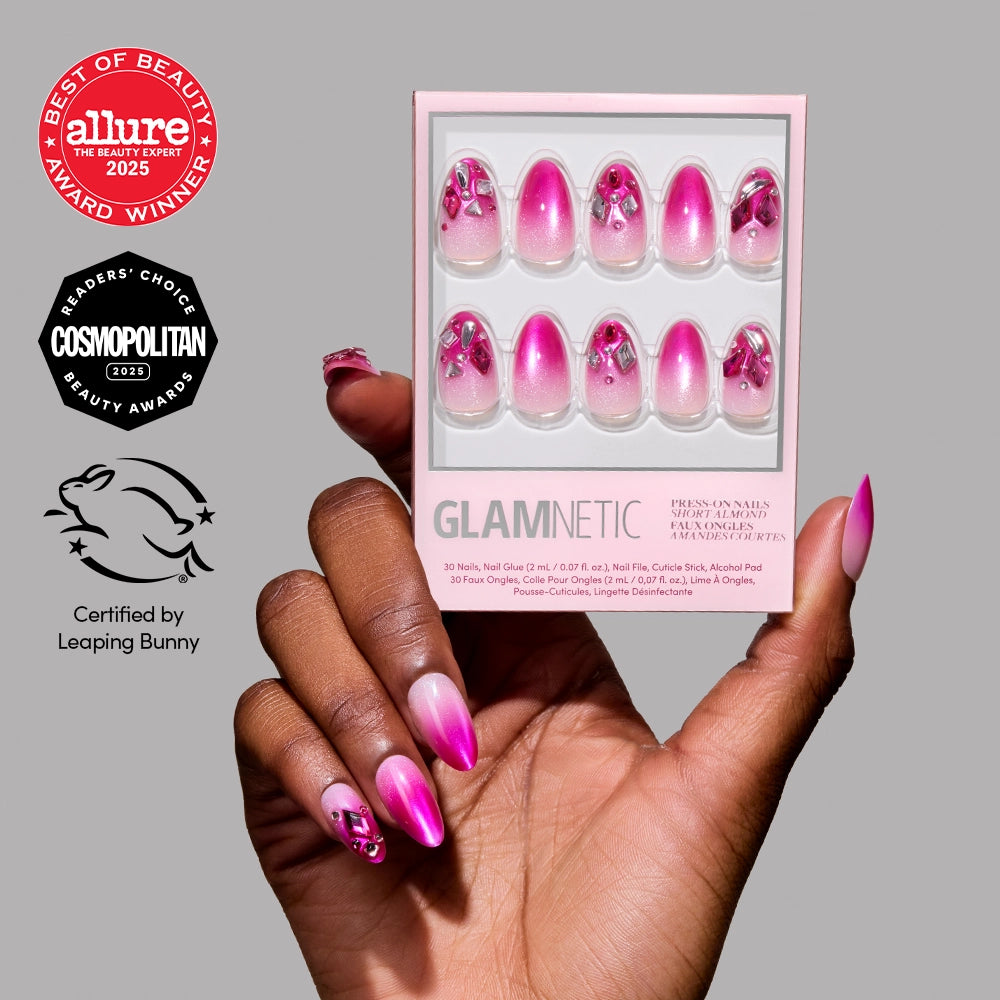 A hand with short, almond-shaped pink and white ombre press-on nails holds a box of glamnetic Pink Tourmaline. Allure and Cosmopolitan beauty award badges and a Leaping Bunny certification logo are shown beside the hand.