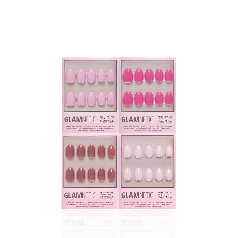 Four boxes of Glamnetic Pretty in Pink Ovals press-on nails are arranged in a grid on a white background. Each set features ten short oval nails in shades of pink and nude, beautifully displayed in a rectangular pink box with clear plastic windows. - Product image