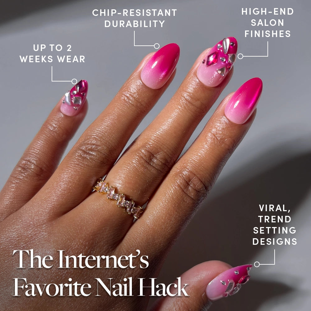 A hand showcases glamnetic's Pink Tourmaline press-on nails—short almond nails with a stunning pink gradient, gem embellishments, and trendy ombré design. Text highlights benefits: up to 2 weeks of wear, chip-resistant durability, salon-quality finish, and fashion-forward style. A gemstone ring adorns the middle finger. Ideal for anyone seeking the elegance of Pink Tourmaline press-ons or boldly reimagined short almond nails. - Product image