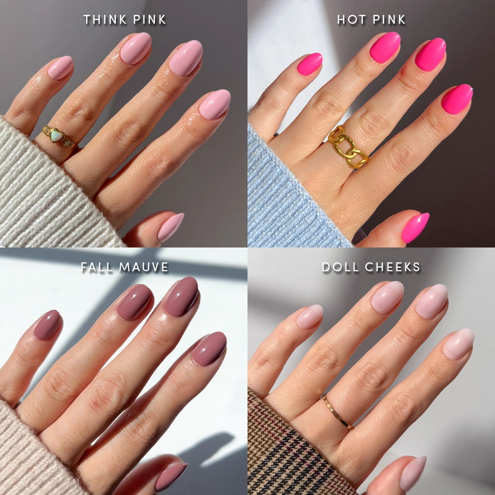 Four hands display short oval nails from the glamnetic Pretty in Pink Ovals set, each manicured in a different shade: Think Pink (pale pink), Hot Pink (bright pink), Fall Mauve (mauve), and Doll Cheeks (light nude pink). Every hand is adorned with a ring and a colorful sweater, perfectly highlighting this chic pink nail set. - Product image