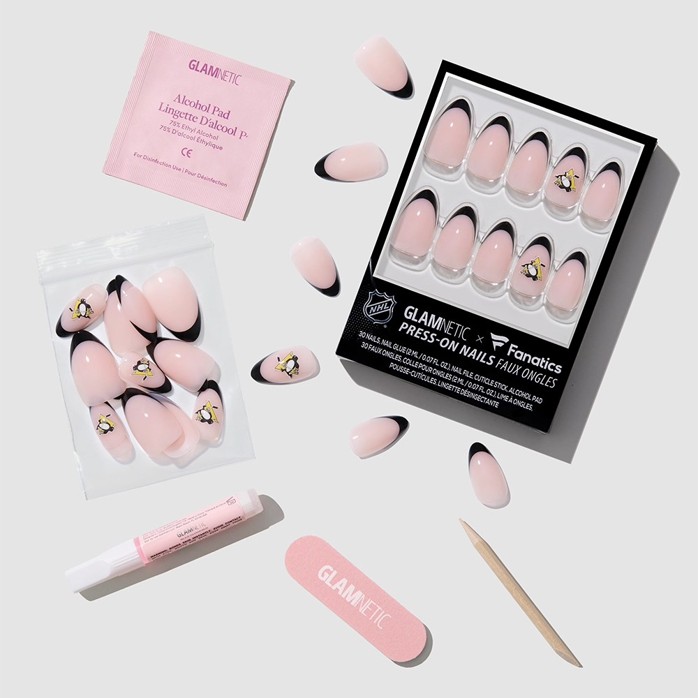 The glamnetic Pittsburgh Penguins Press-On Nail Set features pink nails with black French tips and yellow flower accents, shown with nail glue, a cuticle stick, pink file, alcohol pad, and extra nails on a white background. - Product image