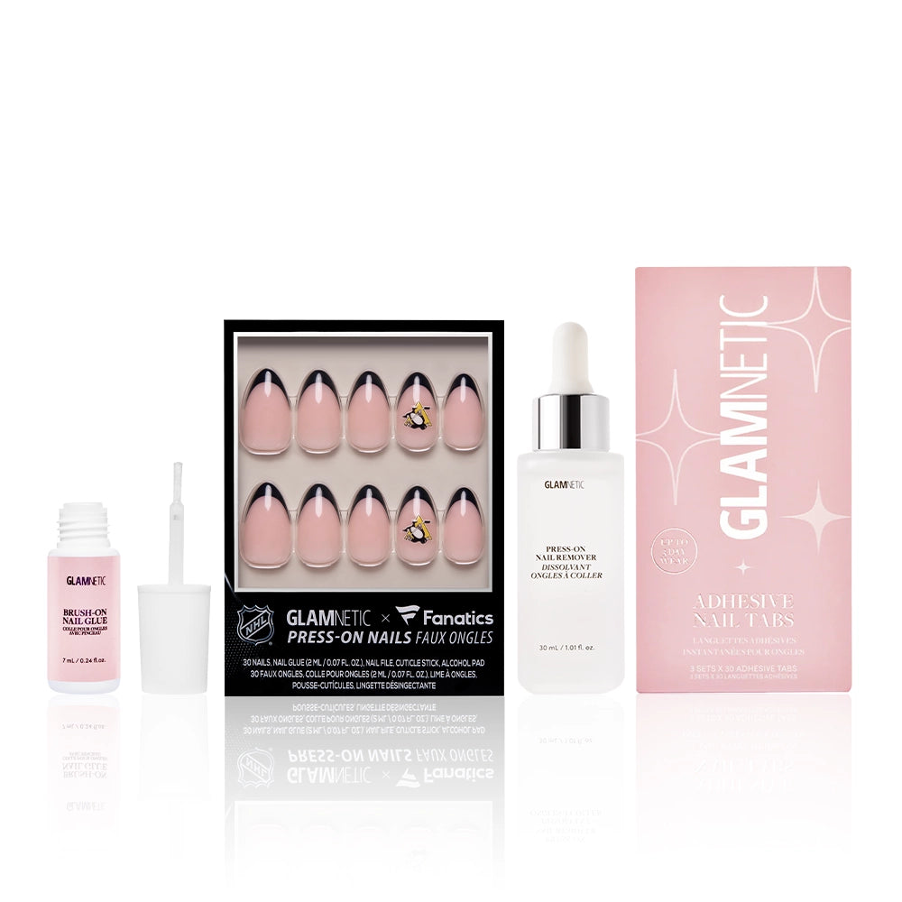 A box of glamnetic The Pittsburgh Penguins Lineup press-on nails, a bottle of nail glue with an open brush, a bottle of nail lacquer, and a pink Glamnetic Adhesive Nail Tabs box arranged side by side.