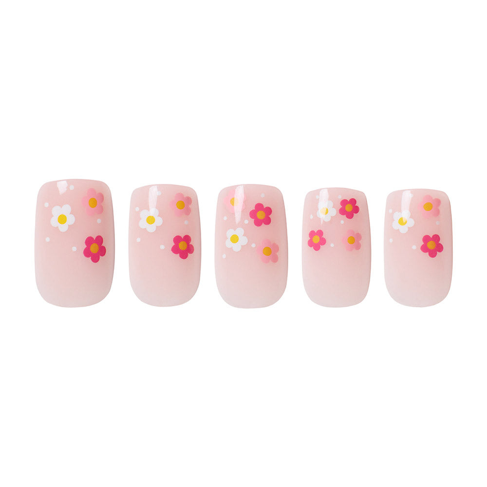 The Pretty Bloom set by glamnetic features five pink short squoval glossy nails, each adorned with small white, yellow, and pink flower designs plus white dots, arranged in a row against a white background. - Product image
