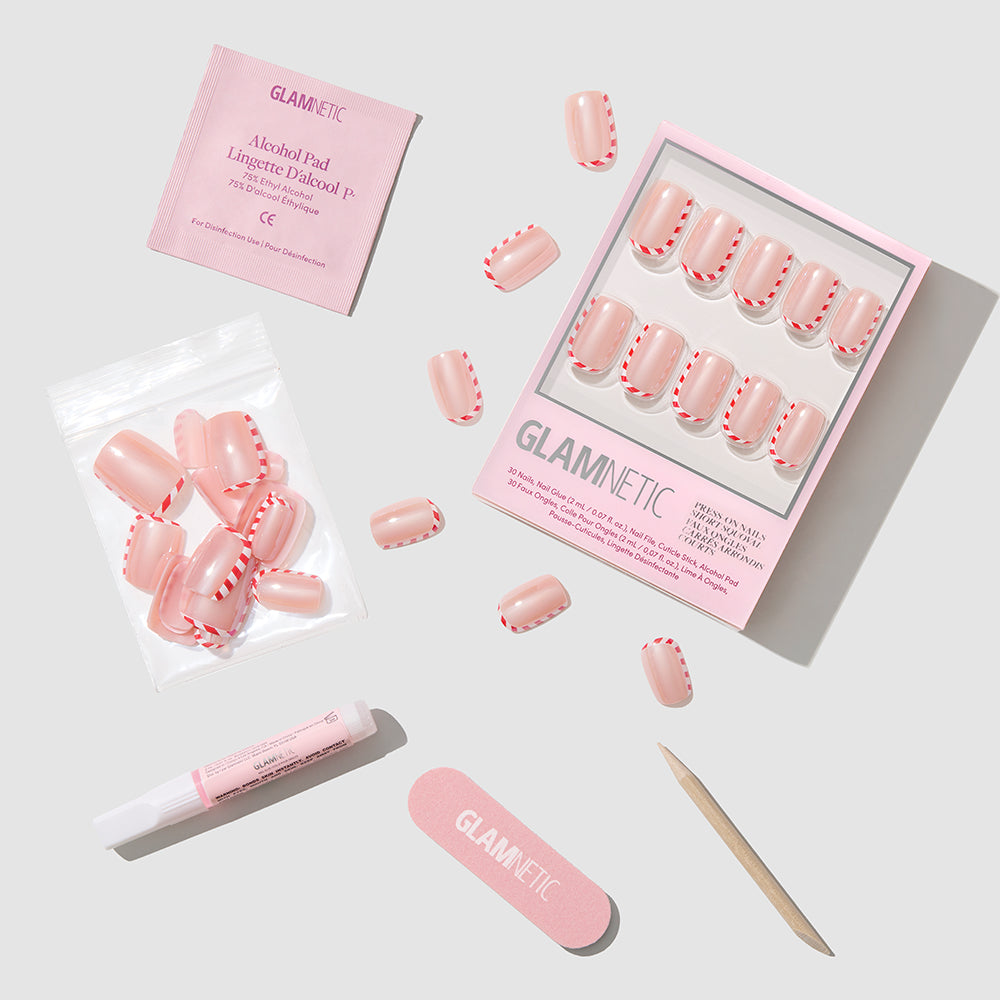 Pretty in Peppermint - Glamnetic Pretty in Peppermint short oval press-on nails featuring a white and red candy-cane stripe pattern, displayed with nail glue, a nail file, a cuticle stick, and an alcohol prep pad.
