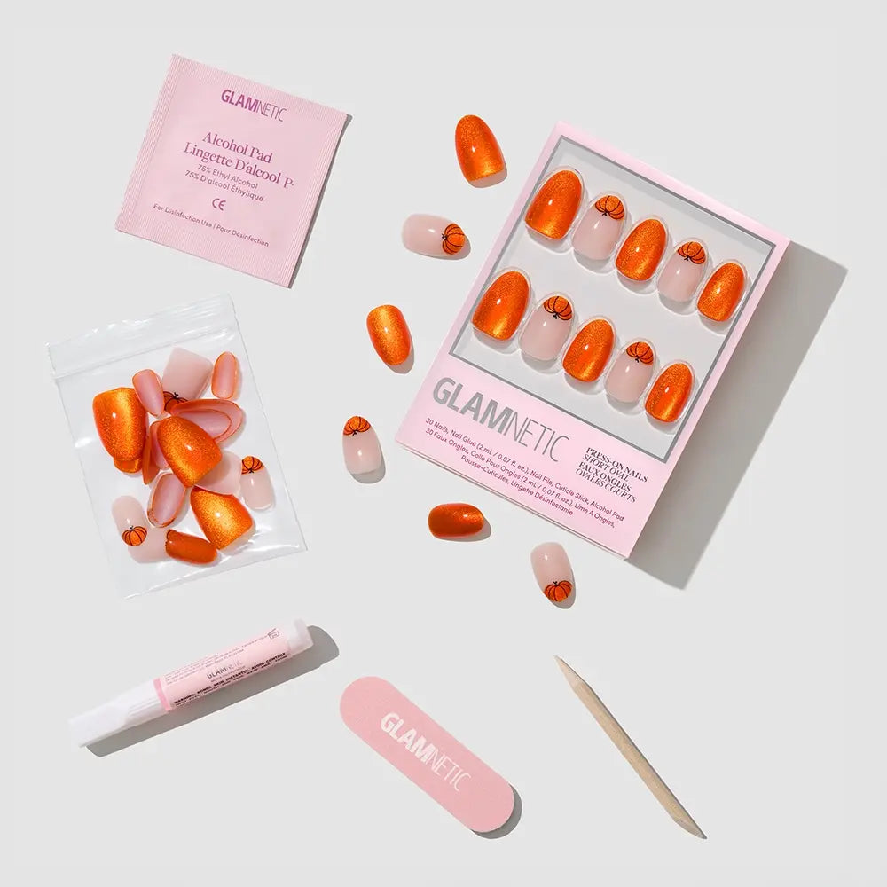 The glamnetic Pumpkin Patch Nail Set includes orange and nude heart press-ons, extra nails, alcohol pad, nail glue, nail file, and cuticle stick—all displayed on white with “glamnetic” packaging. - Product image