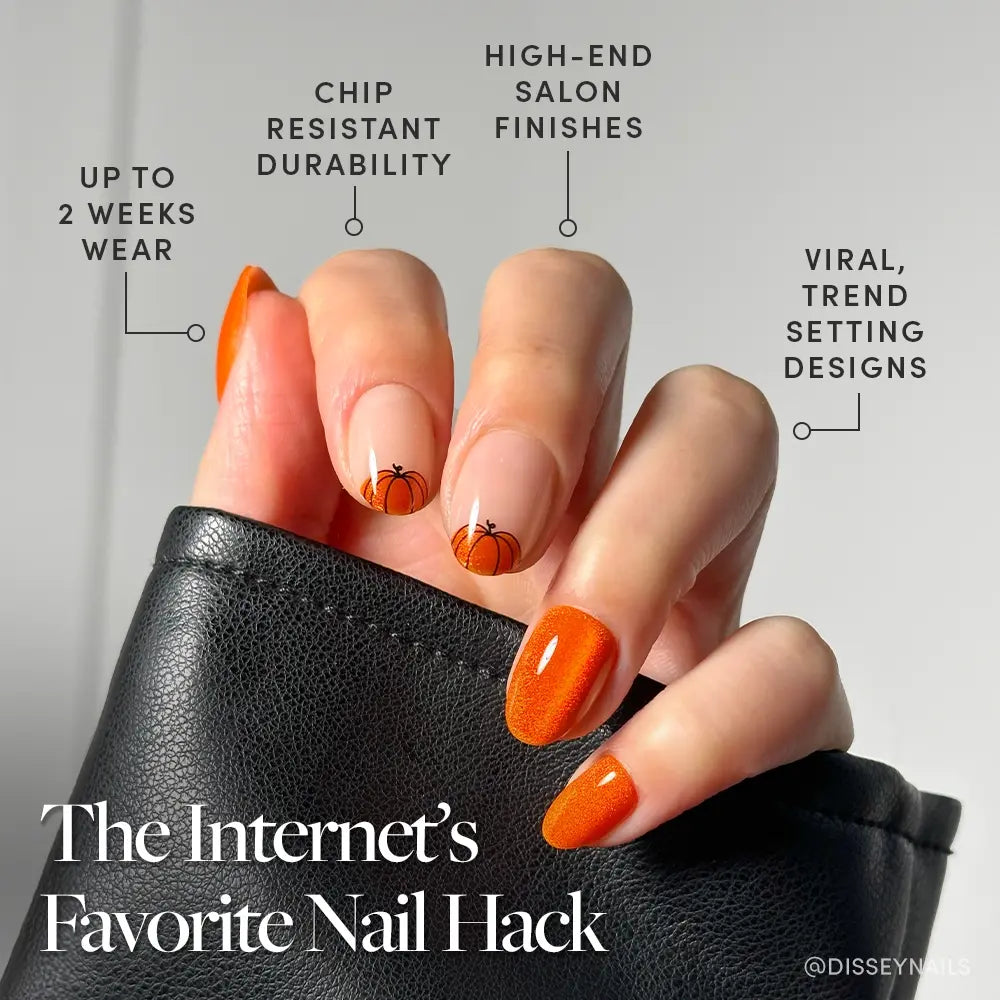 A hand with Pumpkin Patch pumpkin orange velvet nails by glamnetic, featuring small pumpkin art, holds a black leather item. Enjoy up to 2 weeks wear, chip resistance, high-end finishes, and viral trend-setting designs. - Product image