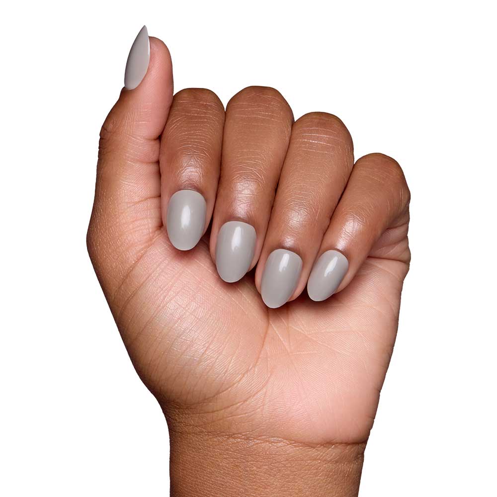 A hand with medium brown skin displays neatly manicured gray nails in a glossy finish from glamnetic’s Pure Gray set, shown against a white background. - Product image