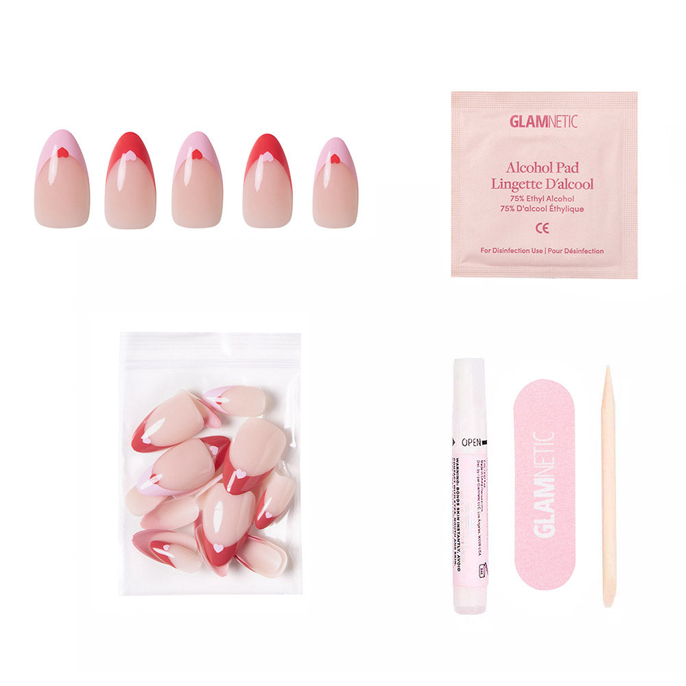 Pure Hearted by glamnetic features pink almond nails with red, white, and heart accents—ideal for Valentine’s Day. Set includes extra nails, alcohol pad, nail glue, file, and cuticle stick arranged on a white background. - Product image
