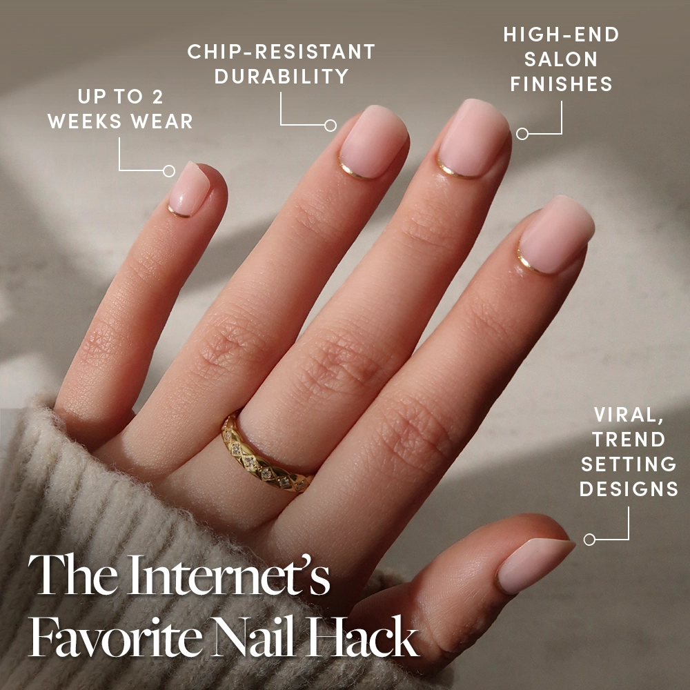 A hand with glamnetic Quiet Luxury press-on nails shows off pale pink color, gold accents, a gold French tip, and a chic ring. Enjoy chip-resistant durability, up to 2 weeks’ wear, salon-quality finish, and viral trendy design. - Product image