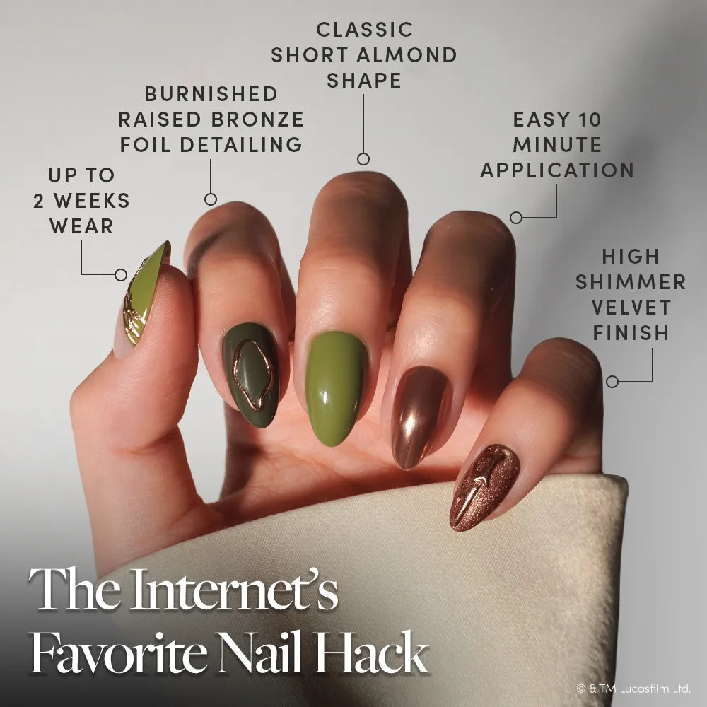Rebellion - A hand displays manicured, short almond-shaped nails featuring glamnetic’s Rebellion Press-On Nail Set, with olive green and metallic bronze polish, foil detailing, and a shimmery finish. These easy-to-apply nails offer up to two weeks of wear—ideal for anyone seeking bold style with lasting power.