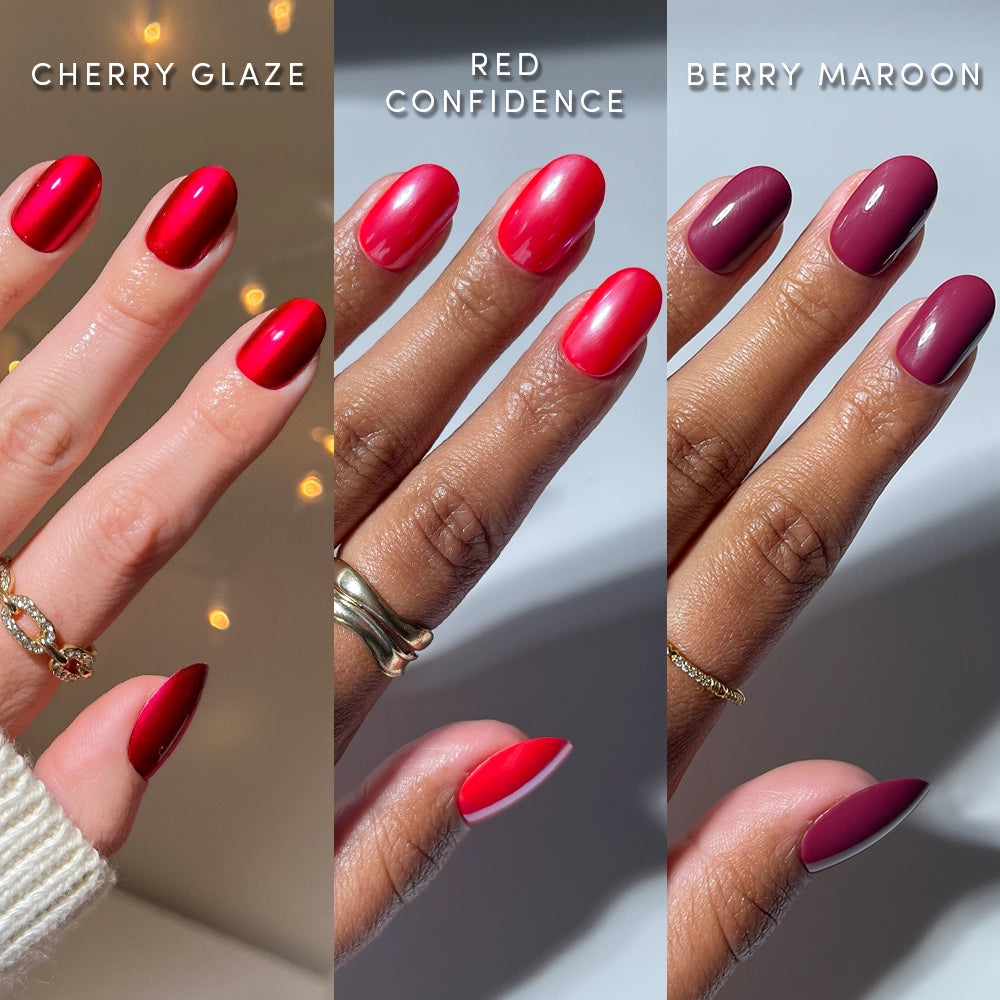 Three hands, each styled with short, round press-on nails in vibrant cherry red, glossy crimson, and matte berry maroon from glamnetic’s Round in Red collection. Each hand is adorned with gold rings against softly lit backgrounds—showcasing salon-quality manicures with these chic glamnetic press-ons. - Product image