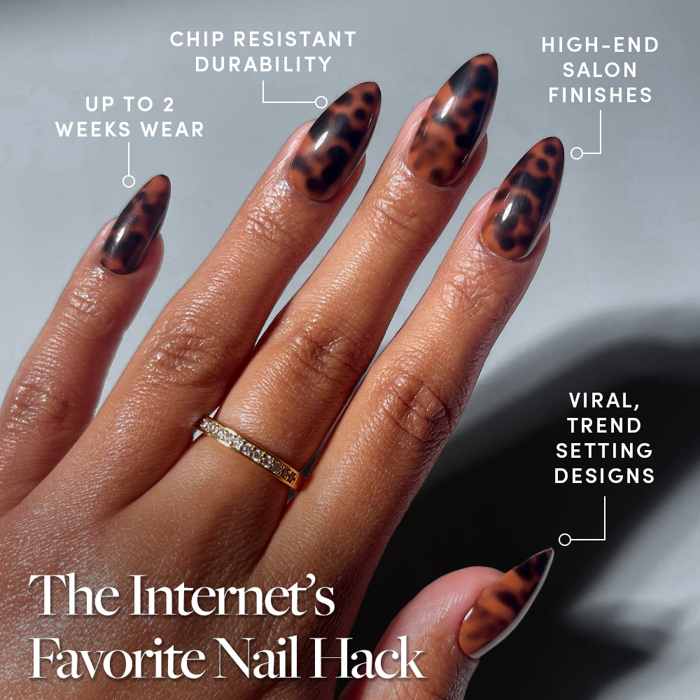 A hand flaunts glamnetic’s Rich Behavior press-ons—salon-quality, almond nails in a brown tortoiseshell design. Enjoy chip-resistant durability, high-end salon finishes, viral trend-setting style, and up to 2 weeks’ wear. - Product image