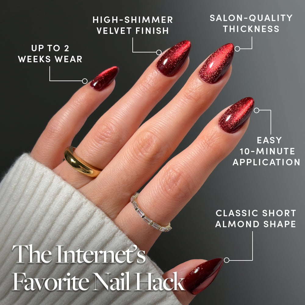 Ruby Slipper - A hand displays short almond-shaped Ruby Slipper nails by Glamnetic, featuring a velvet finish, salon-quality thickness, two-week wear, and a 10-minute application.