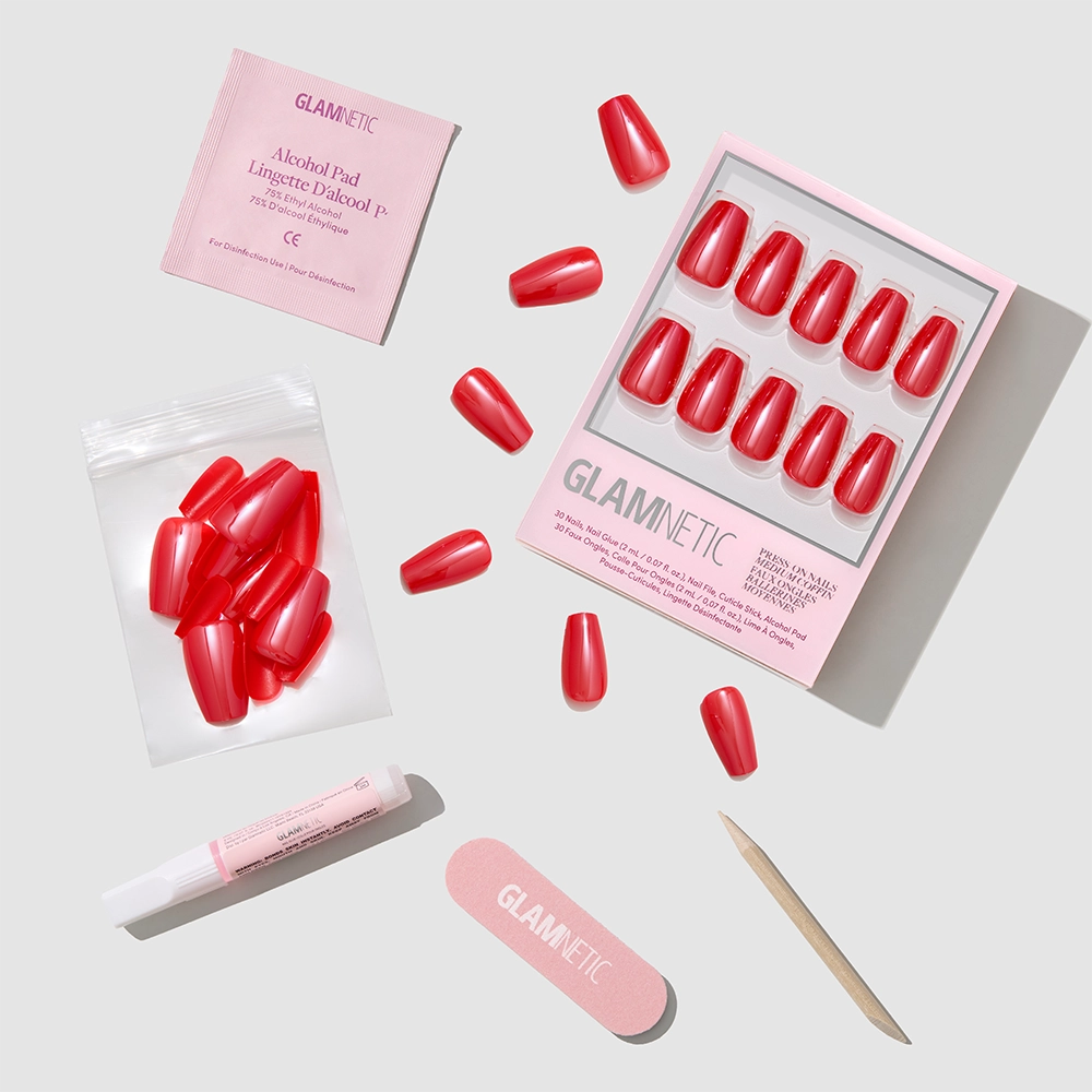 The glamnetic Runway Red Press-On Nails set includes chic coffin-shaped nails, a nail file, cuticle stick, adhesive, alcohol pad, and extra nails—offering a salon-quality mani on a light gray background.
