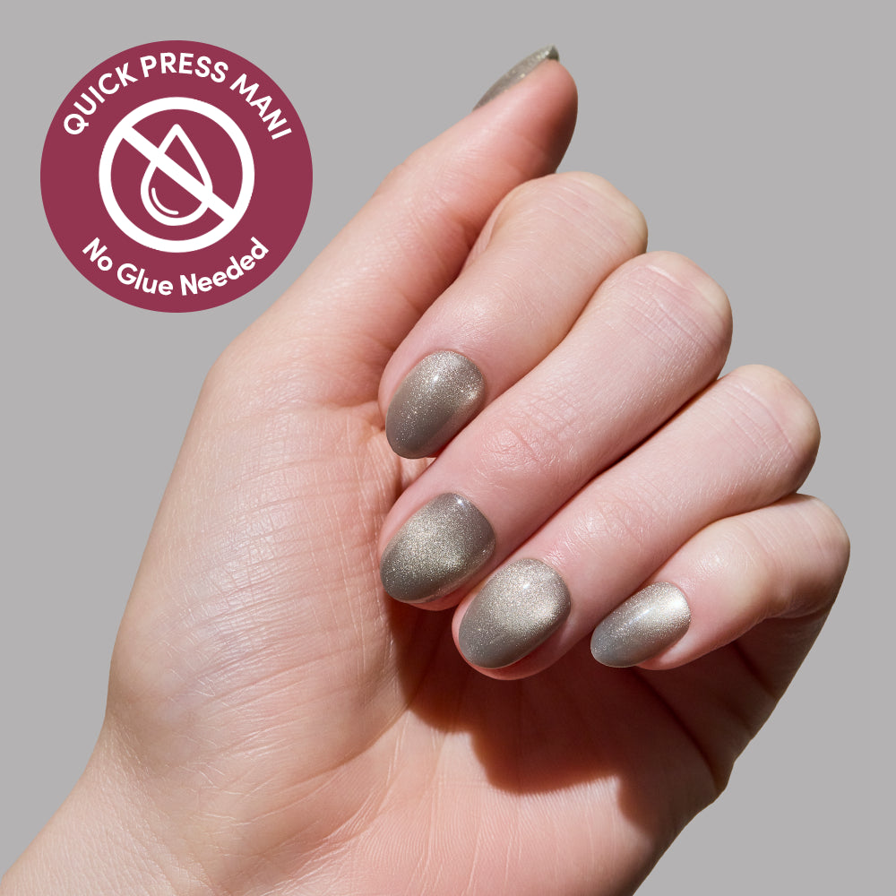 A hand with short, almond-shaped Sparkly Moss stick-on nails by glamnetic is shown against a plain gray background. A circular badge reads Quick Press Mani, No Glue Needed with a droplet icon crossed out. - Product image