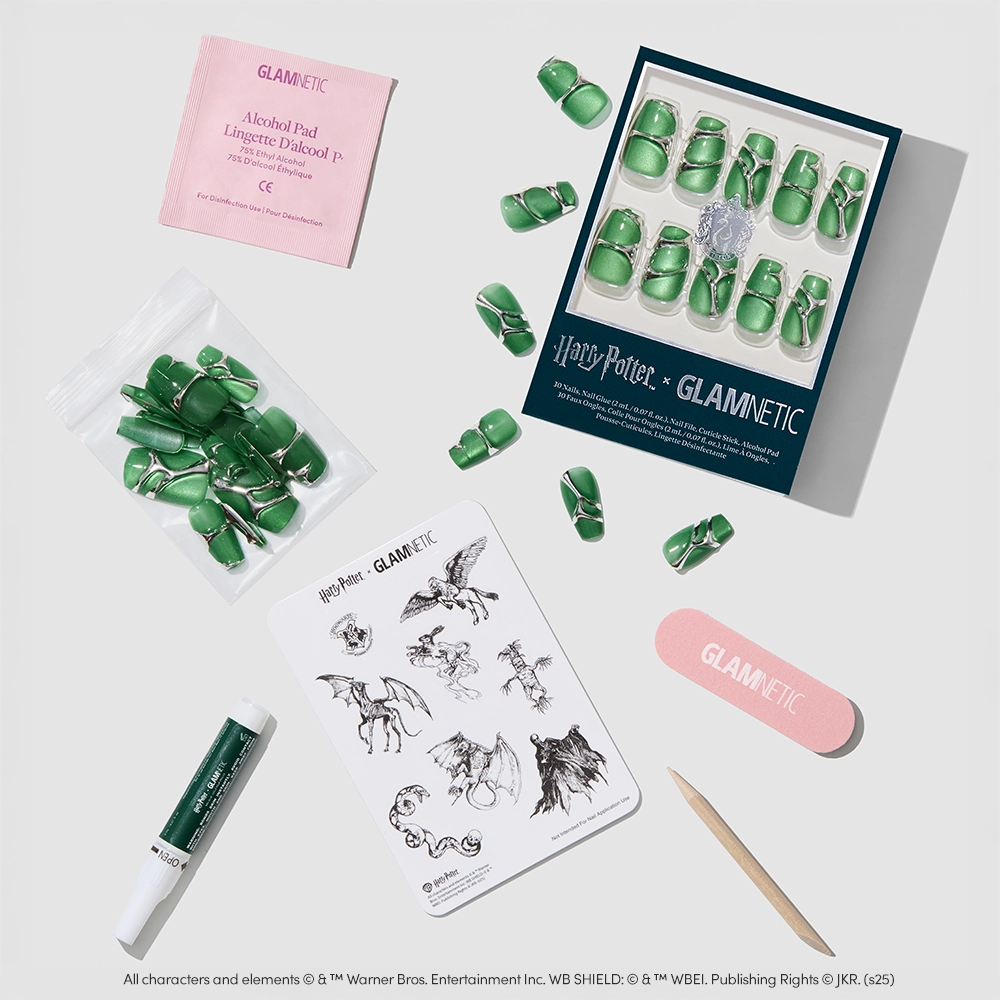 A flat lay of the Salazar Slytherin™ nail set by glamnetic, featuring green velvet coffin nails, nail glue, alcohol pad, nail file, and black-and-white Harry Potter-themed stickers. - Product image