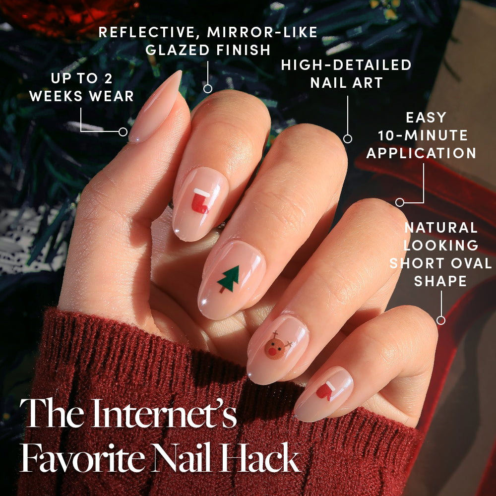 Santa's Babies - Short, oval, neutral-toned Glamnetic Santa’s Babies holiday nail set featuring small Christmas-themed decals, including a stocking, tree, reindeer, and mitten on each press-on nail.