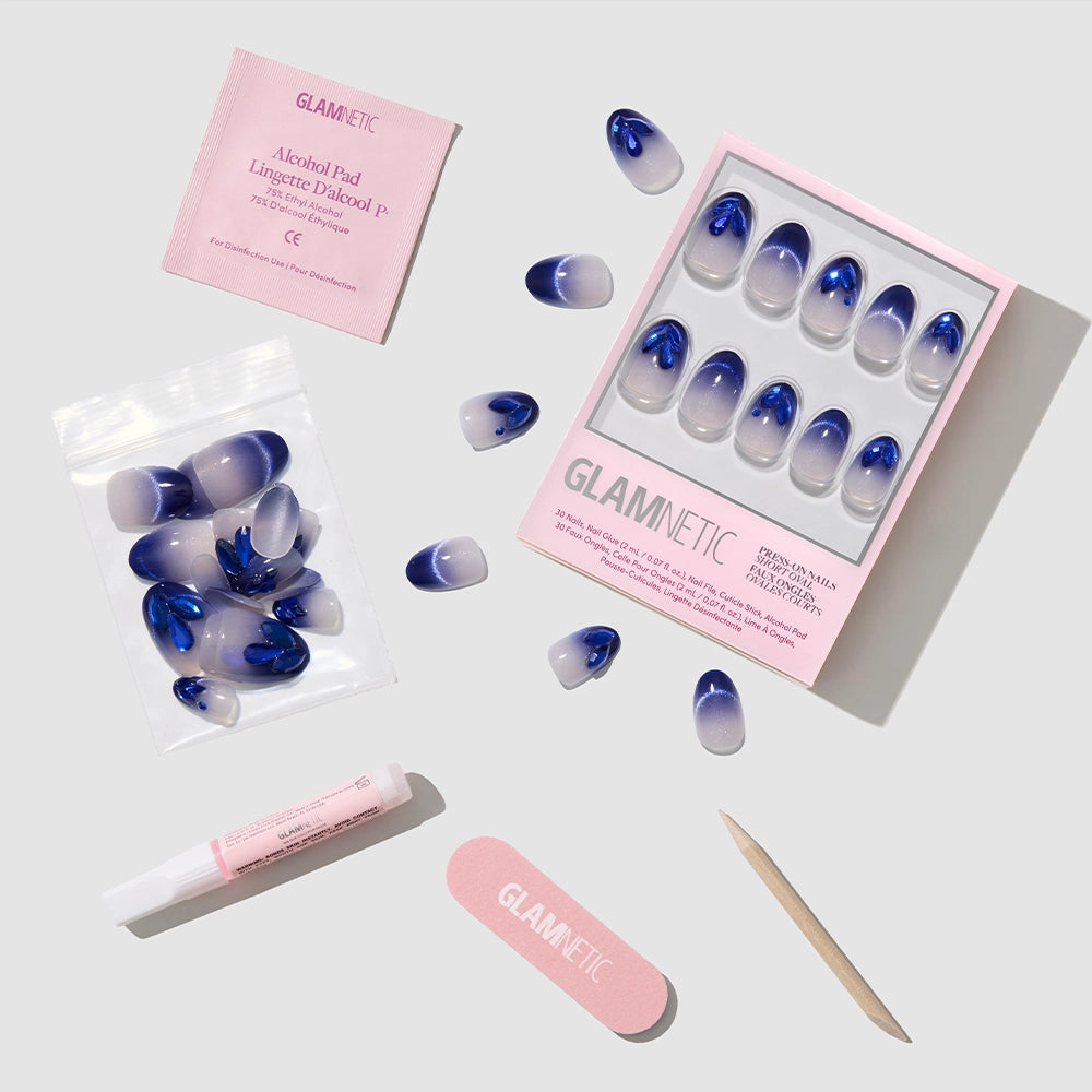 The glamnetic Sapphire Press-On Nails set includes blue and purple nails, a pink nail file, wooden cuticle stick, nail glue, alcohol pad, and extra nails—perfect for creating stunning gemstone-inspired nail art. - Product image