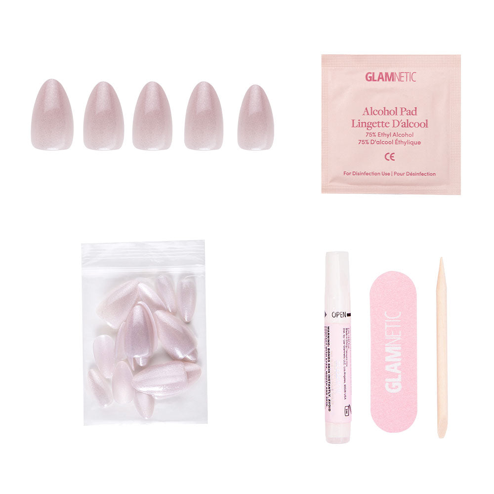 The glamnetic Selenite Nail Set includes five short almond-shaped pink nails, extra nails, an alcohol pad, glue tube, pink nail file, and wooden cuticle stick—all arranged on a white background. - Product image
