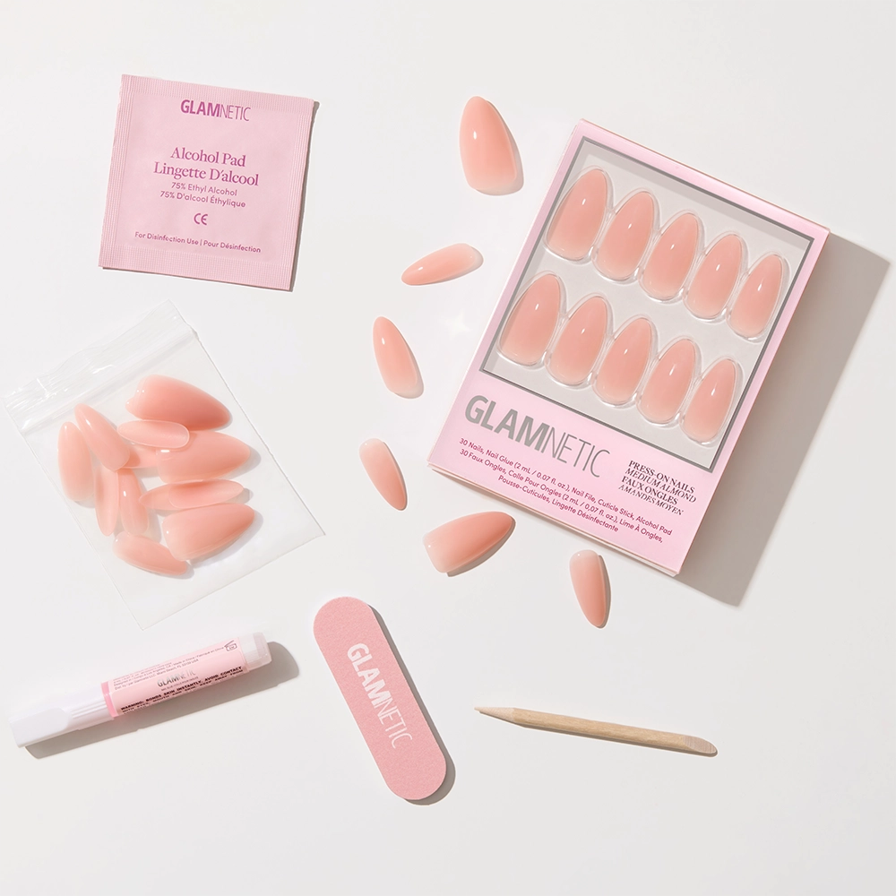 The glamnetic Sheer Pink set includes pink press-on nails, a nail file, wooden cuticle stick, glue, extra nails in a bag, and an alcohol pad—everything you need for a clean-girl look or soft-glam aesthetic. - Product image