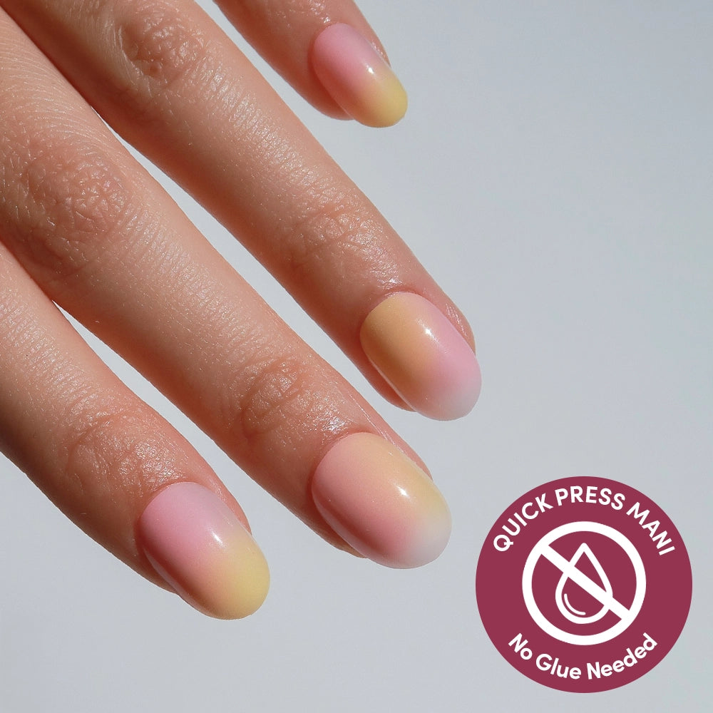 A hand with glamnetic Sherbert press-on nails in a soft pink and yellow ombre. A circular icon reads "Quick Press Mani, No Glue Needed" with a crossed-out droplet symbol.