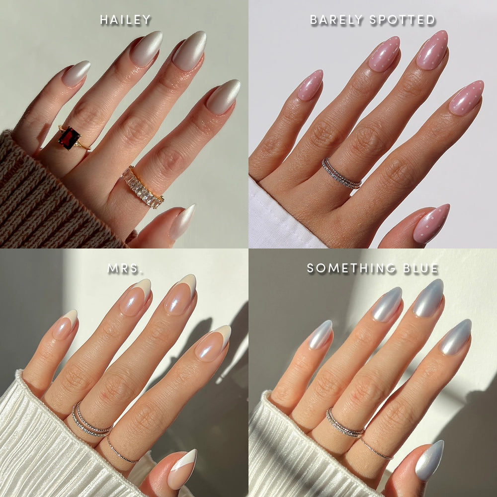 Four images of manicured hands featuring different nail designs applied with glamnetic’s Short Almond Syllabus press-on nails: a crisp white (Hailey), delicate light pink (Barely Spotted), pastel French tips (Mrs.), and a shimmery light blue (Something Blue). Each hand is styled with chic rings and cozy sweater sleeves, highlighting the salon-quality finish of glamnetic’s press-ons for an effortlessly stylish look. - Product image