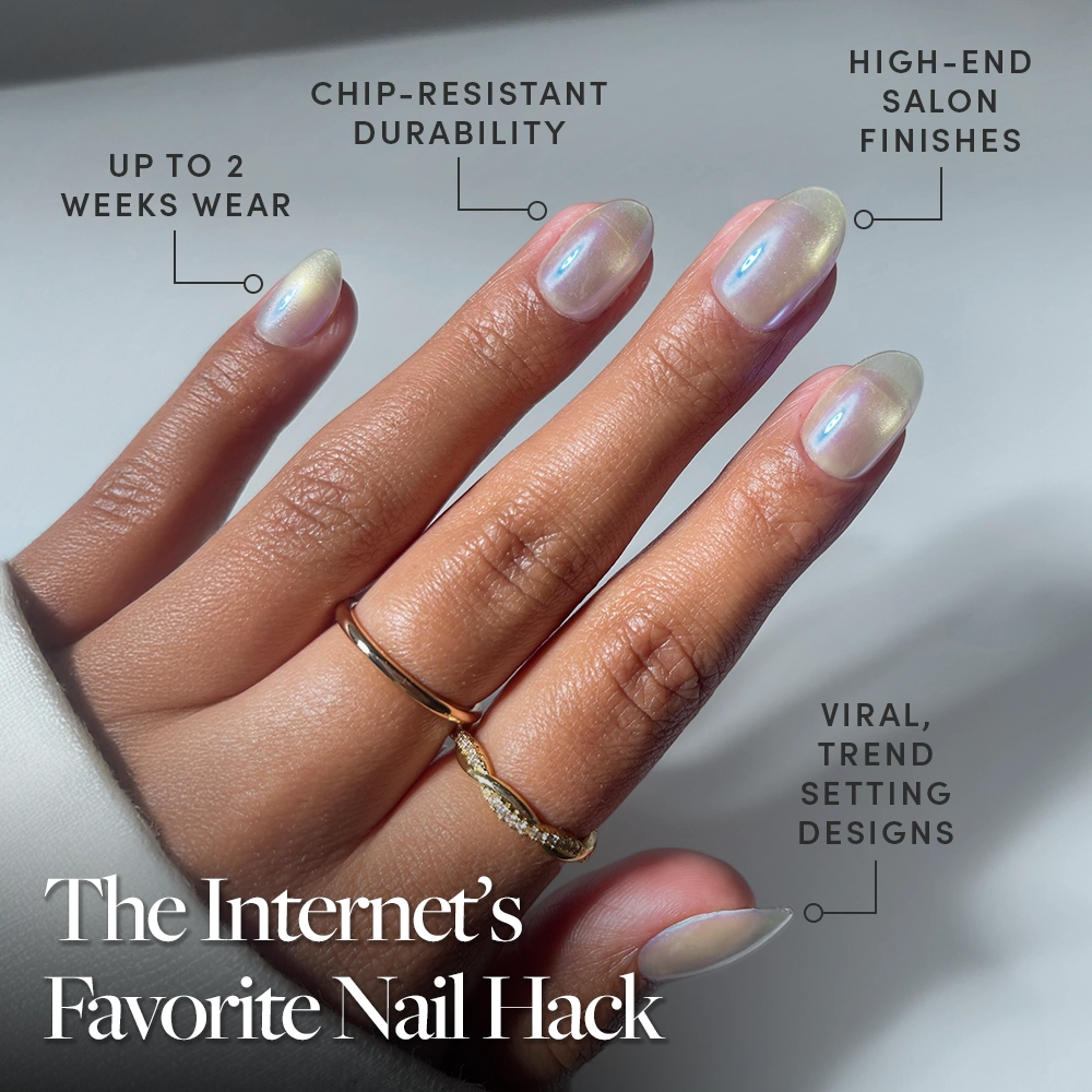 A hand with semi-sheer grey, iridescent Silver Siren nails by glamnetic is shown on short ovals with two gold rings. Benefits: up to 2 weeks of chip-resistant wear, salon-quality shine, and trending viral designs. - Product image