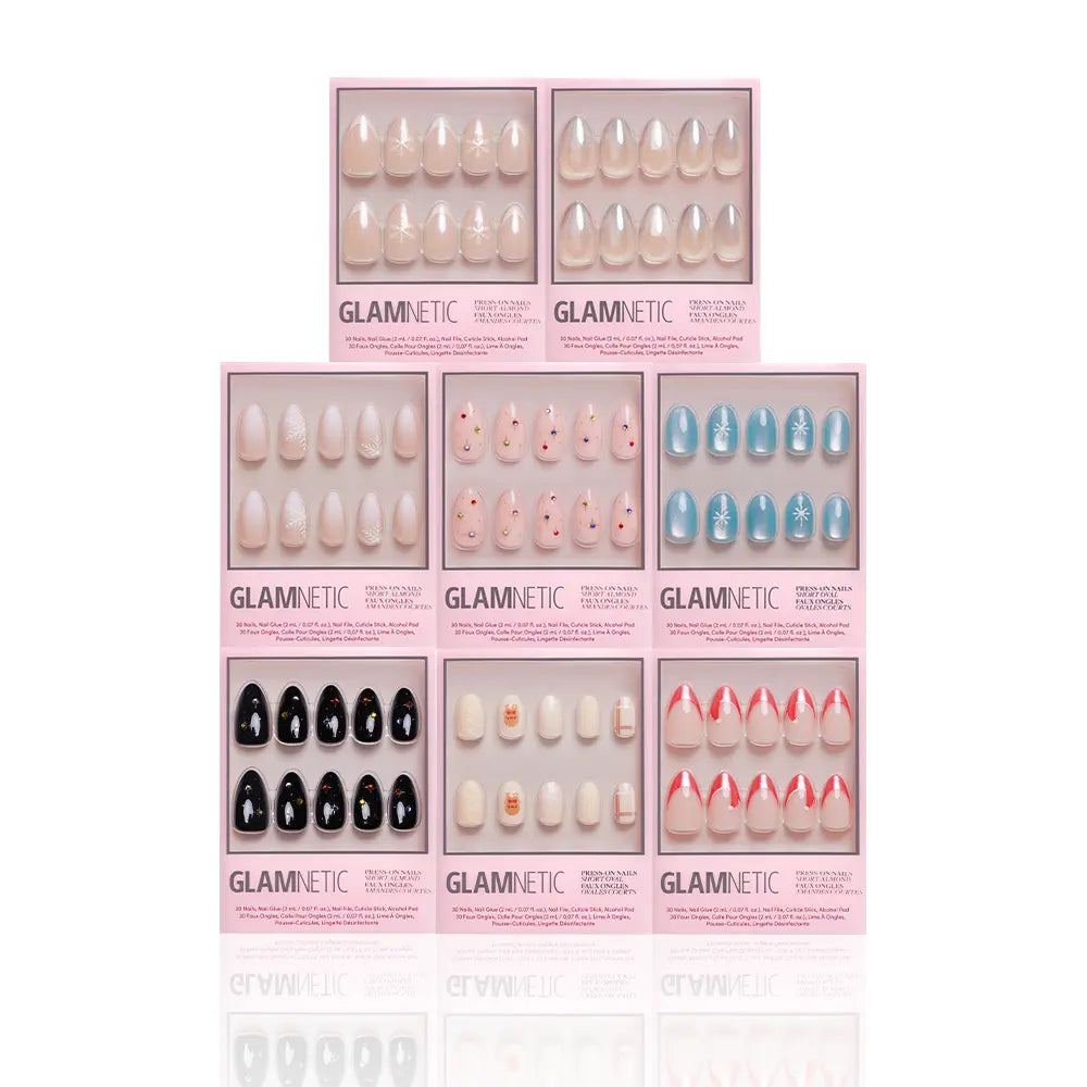 Eight boxes from the glamnetic Snow Place Like Home Collection are arranged in two rows, displaying festive winter press-on nail designs in nude, black, blue, red or pink tips, plus playful face accents—ideal for stylish holiday looks. - Product image