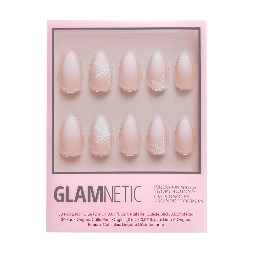 A box of glamnetic Snowdrift press-on nails in a short almond shape, featuring a matte light pink gradient with raised snowflakes, shown through a clear window in sleek pink packaging. - Product image