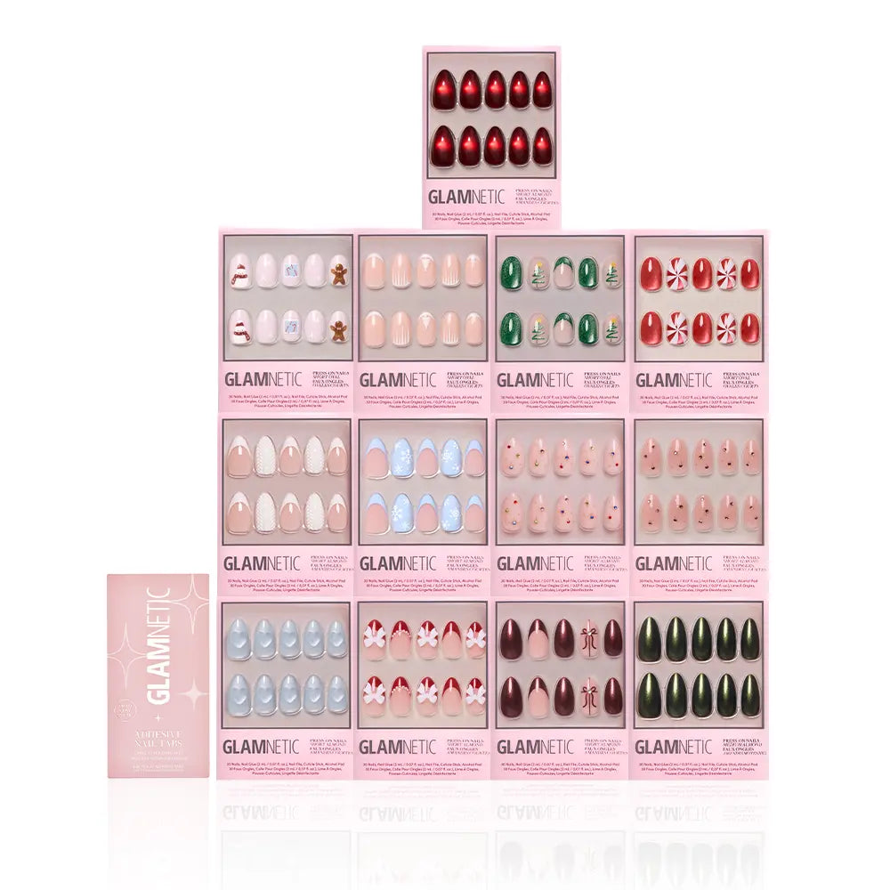 A display of fourteen glamnetic Snowed In Collection festive nail sets in assorted holiday designs and colors is arranged in a grid, with a pink glamnetic box positioned on the left. - Product image