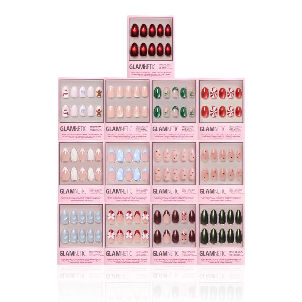A pyramid display of glamnetic’s Snowed In Collection almond press-on nails in pink boxes, featuring festive holiday designs like red, green, blue, nude, candy canes, stars, snowflakes, and Christmas-themed patterns. - Product image