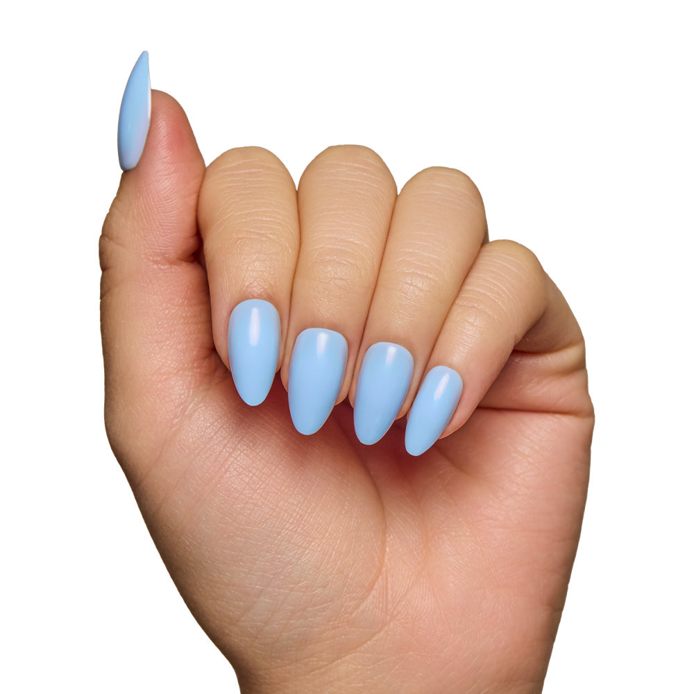 A hand displays the glamnetic Soft Blue short almond nails with a glossy finish against a white background. - Product image