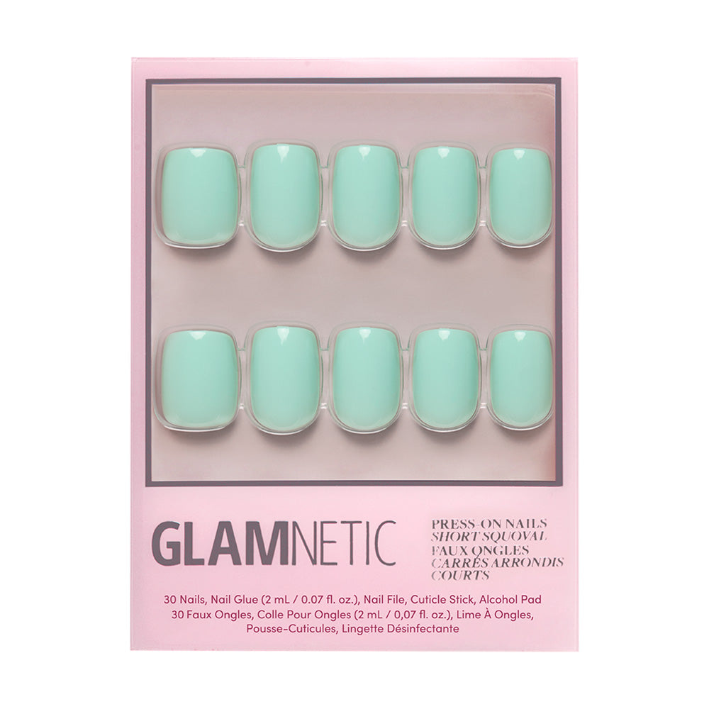 A set of Soft Teal short squoval press-on nails by glamnetic, arranged in two rows inside pink packaging with manicure tools and accessories listed at the bottom. - Product image
