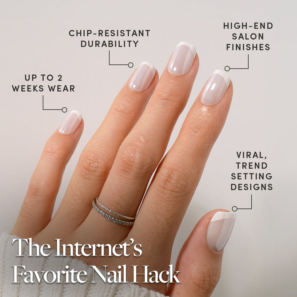 A hand with a French manicure shows off glossy, neatly filed short squoval nails in glamnetic's Soft Tulle press-ons. Text highlights chip-resistant durability, up to 2 weeks of wear, high-end salon finishes, and viral, trend-setting designs—perfect for achieving flawless French tips with the convenience of press-on nails. - Product image
