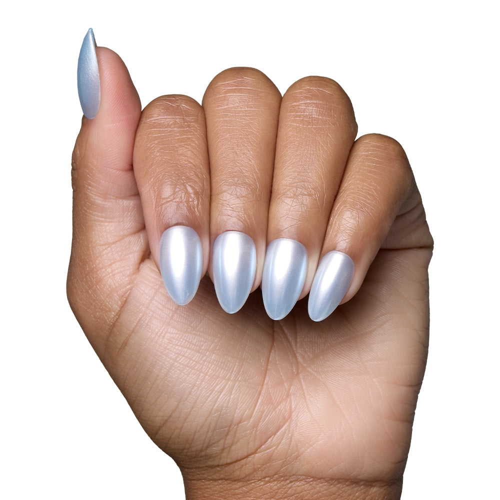 A hand with medium skin tone displays short, salon-quality almond nails painted in glamnetics Something Blue, a shiny, metallic silver-blue polish. The background is plain white. - Product image