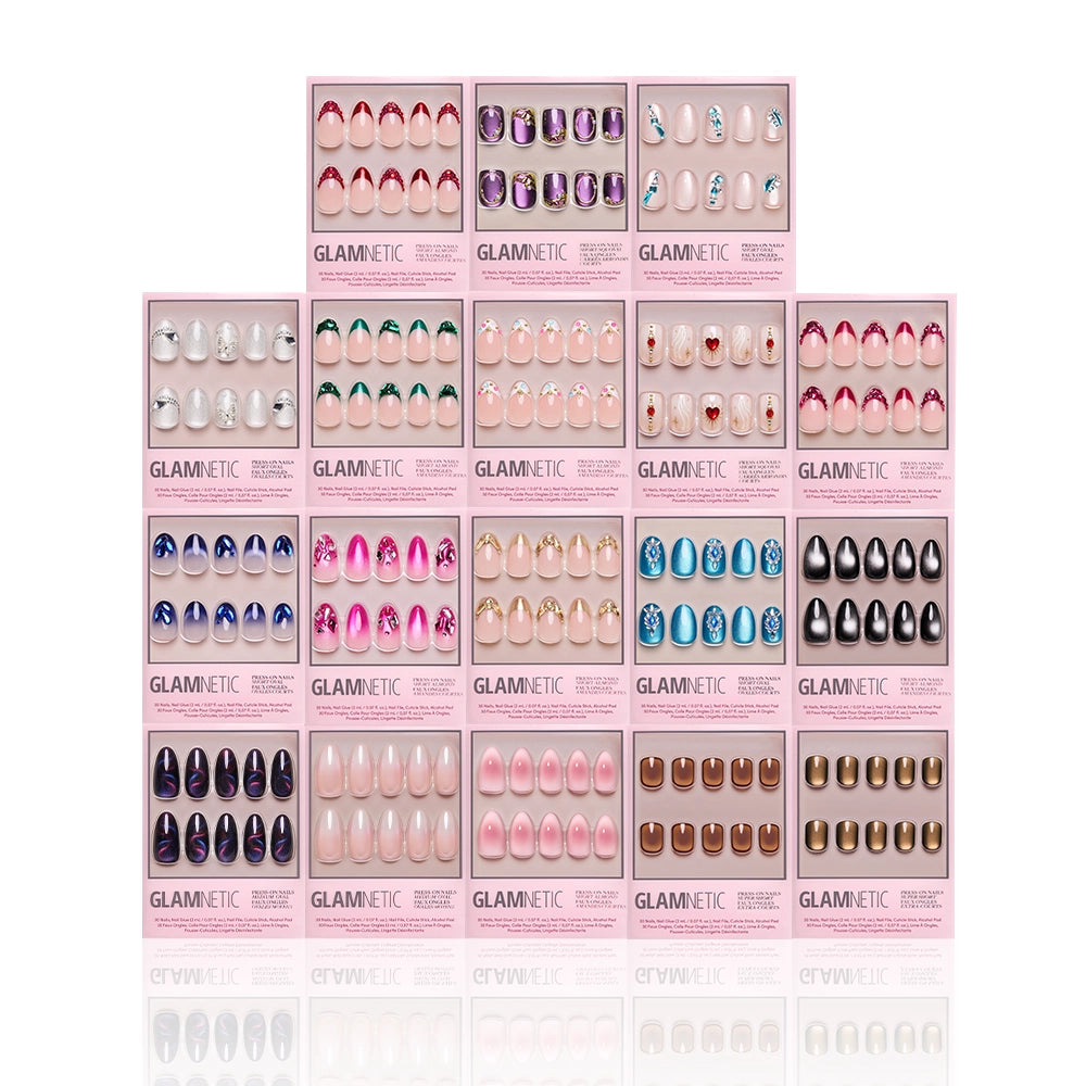 Twenty sets of glamnetic’s Sparkling Gems Collection press-on nails, featuring 3D accents and gemstone designs in assorted colors, are pyramid-arranged on a white background in pink rectangular boxes with clear windows.