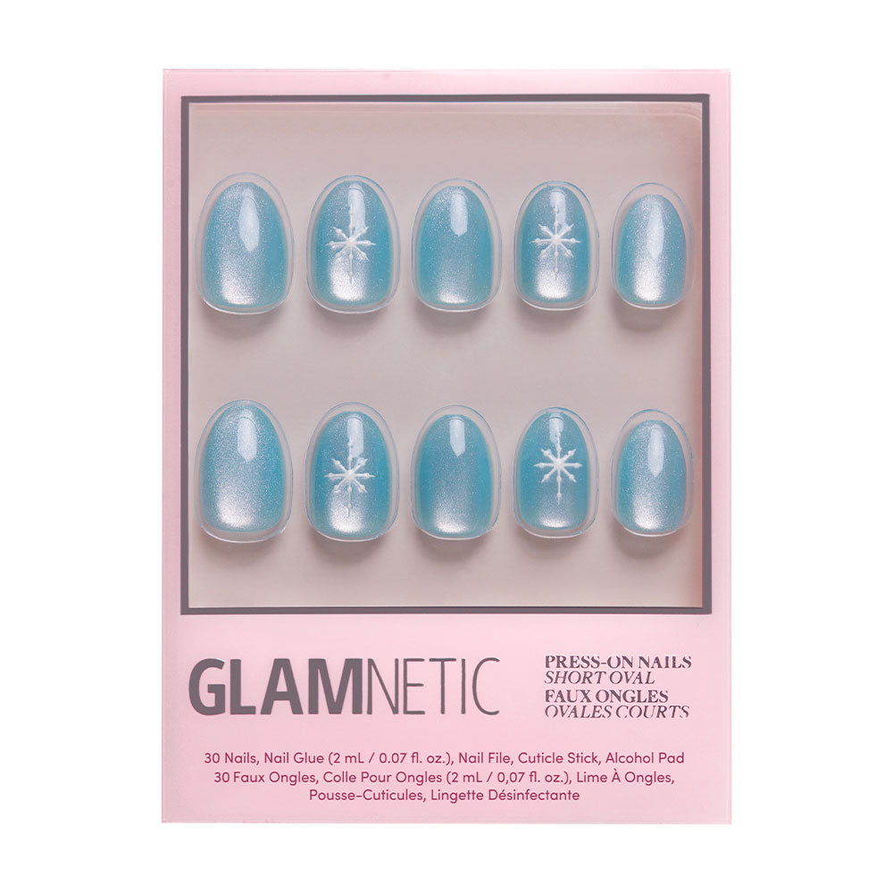 A set of blue velvet-finish press-on nails with white starburst design from glamnetic, called Subzero, in a pink box labeled Subzero Nail Set Press-On Nails Short Oval, with application accessories shown below. - Product image