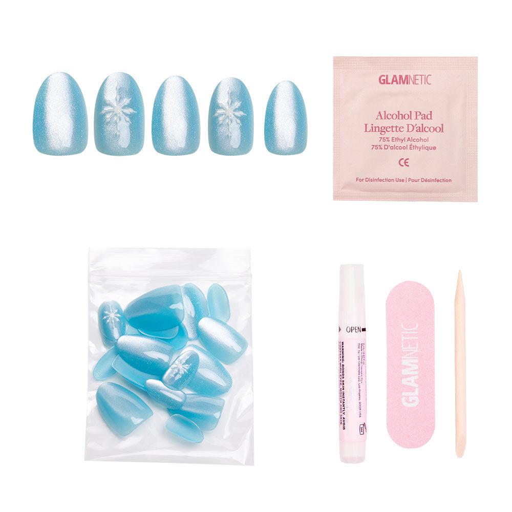 The glamnetic Subzero set features blue velvet-finish press-on nails with white palm tree designs, plus an alcohol pad, extra nails, nail glue, a pink nail file, and a wooden cuticle stick, all shown on a white background. - Product image